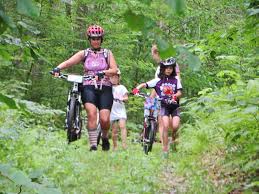 A Little Bellas mentor guides a group of riders through lush forest to familiarize them with the terrain. 