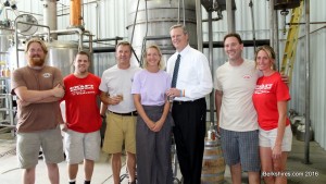 Gov. Charlie Baker poses in front of the stills at Berkshire Mountain Distillers with the owners and staff.
