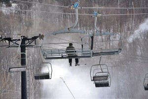With snowguns blazing, a night time skier rides the chairlift at Jiminy Peak Mountain Resort in Hancock.