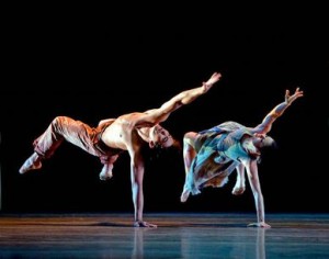 Male & Female dancers from Pacific Northwest Ballet bend back balanced on one hand perfroming Nacho Duato's 