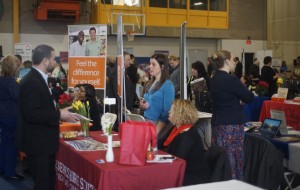 Female career fair participant discusses options at an employer table.