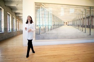 Artist Barbara Earnst Prey laughs as she stands in front of her giant Building 6 Portrait in depicting the Mass MoCA space pre transformation.
